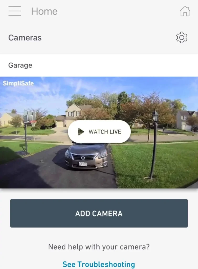 SimpliSafe programėlės ekranas su tiesiogine lauko kameros peržiūra ir mygtukais WATCH LIVE bei ADD CAMERA, vaizdo stebėjimo kameros. SimpliSafe programėlės ekranas su tiesiogine lauko kameros peržiūra ir mygtukais WATCH LIVE bei ADD CAMERA, vaizdo stebėjimo kameros.